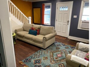 Relax in this inviting living room with a comfortable sofa, patterned rug, and entrance.