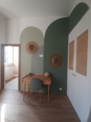 A room with a desk, two chairs, and a door with woven panels.