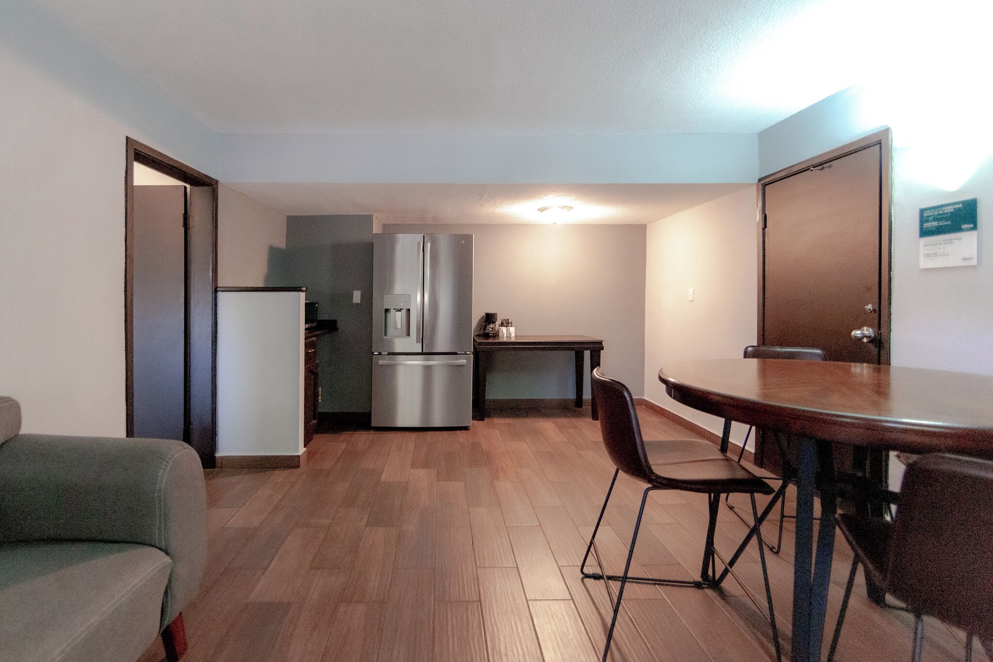 Un espacio habitable compacto con kitchenette, una mesa de comedor y un sofá.