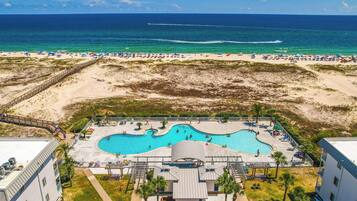 Un resort con piscina, acceso a la playa y vistas al océano.