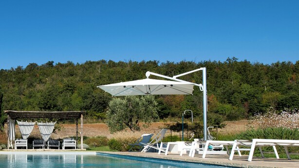A pool area with lounge chairs and a pergola. - 3 bedroom private vacation home in tuscany (Toscana)
