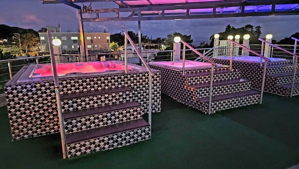 Jacuzzis al aire libre con diseños geométricos, barandas de metal y ambiente nocturno.