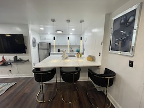 Enjoy dining or socializing at the kitchen island with a large flat-screen TV and appliances.