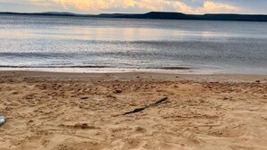 Een strand met een zandstrand en rustig water.