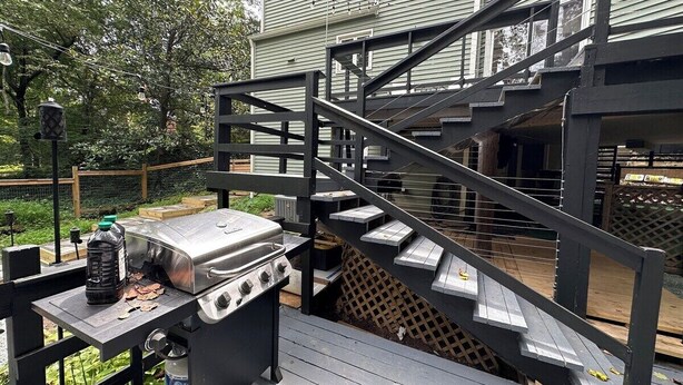 A barbecue grill on a deck with a staircase leading to a covered area. - Duke-Rockwood Gem: 2BR/2BA w/ Office & Fenced Yard (Durham)