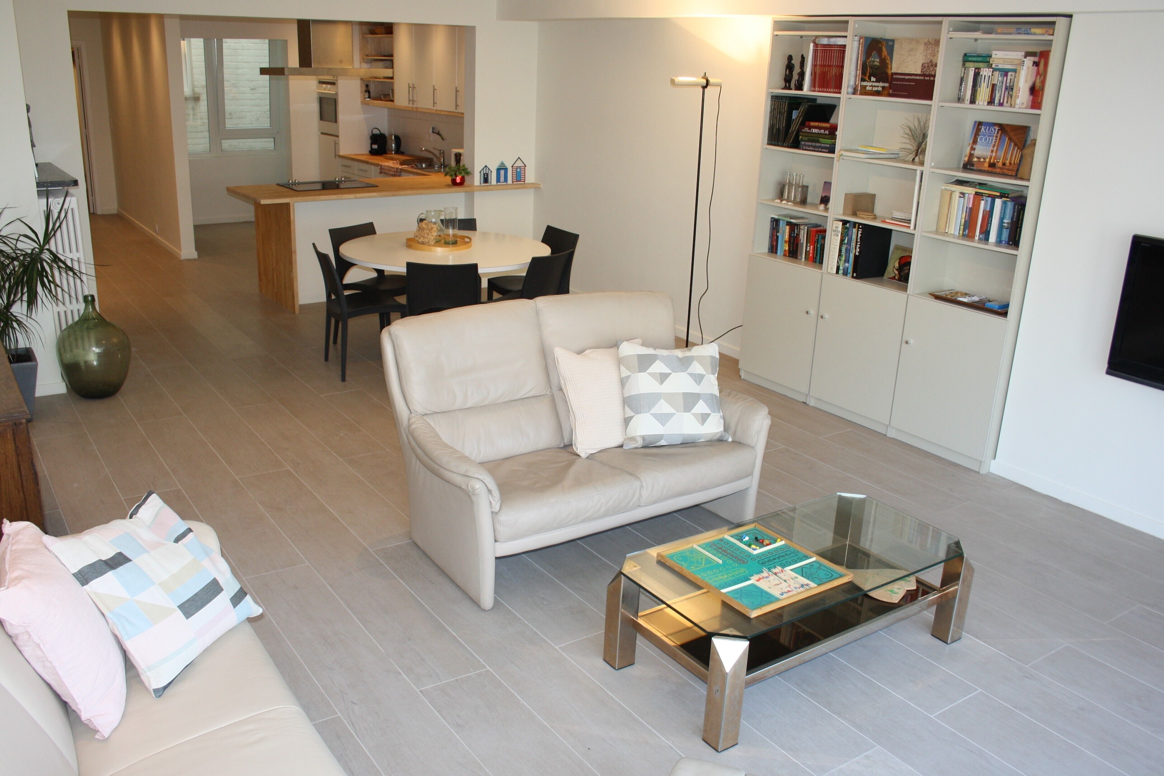 Een moderne woonkamer met een bank, salontafel en een boekenkast.