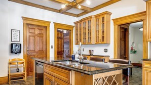 A kitchen with wooden cabinets, a granite countertop, and a built-in wine rack. - Dream Estate Inn (Leamington)