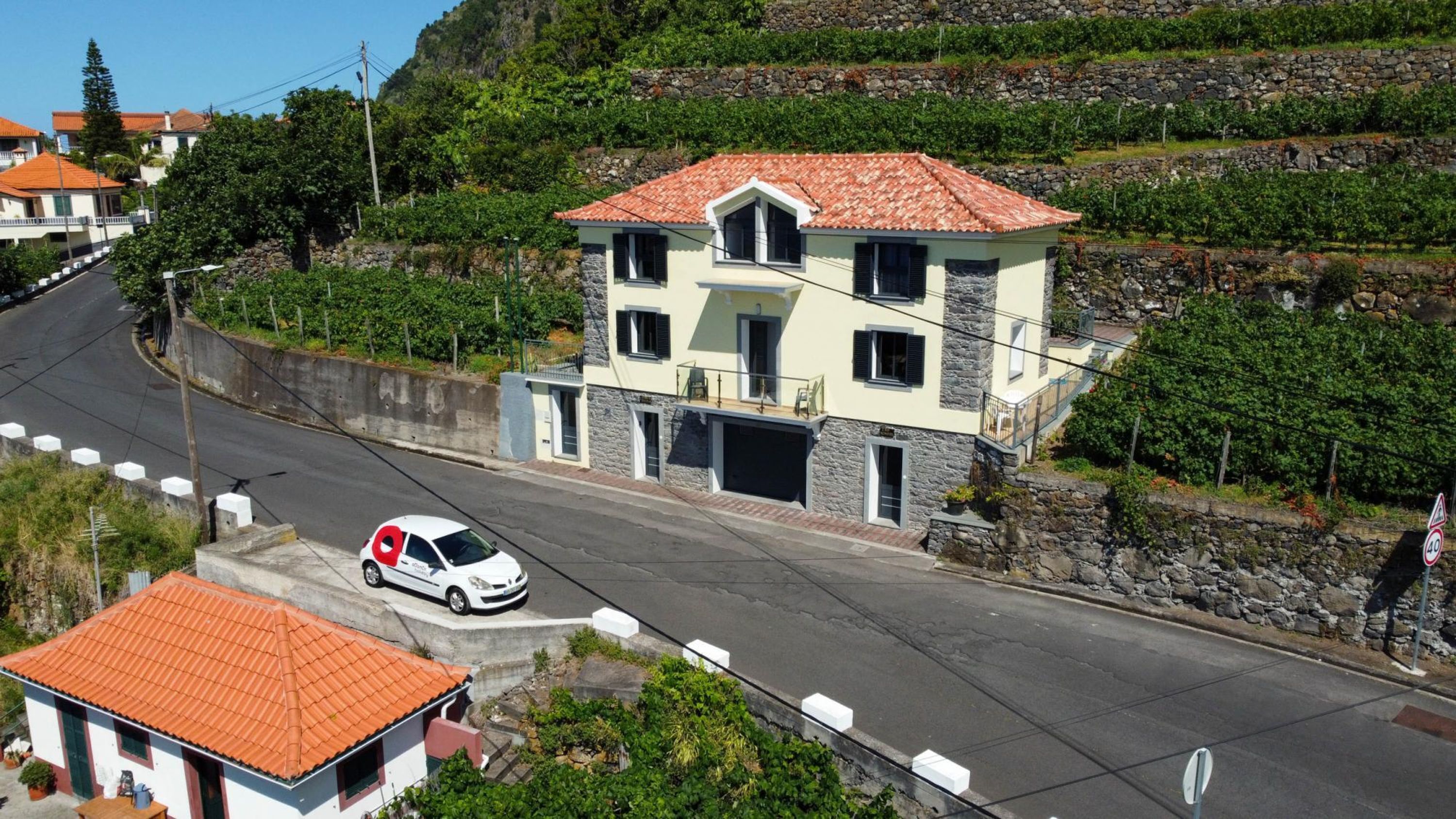 A two-story house with a red-tiled roof, a garage, and a balcony.