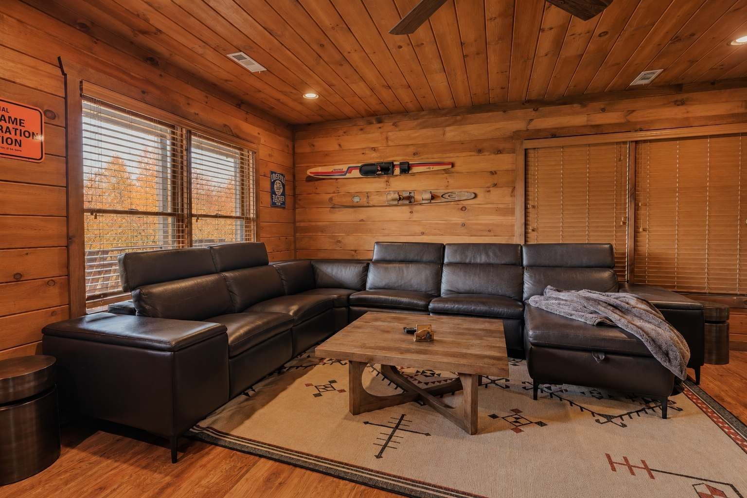 Ein Holzinnenraum mit einem Ecksofa, einem Couchtisch und einem Kamin.