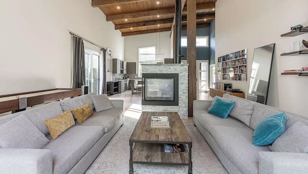 A spacious living room with a fireplace, two sofas, and a coffee table. - Large Modern Home in Squamish (Squamish)