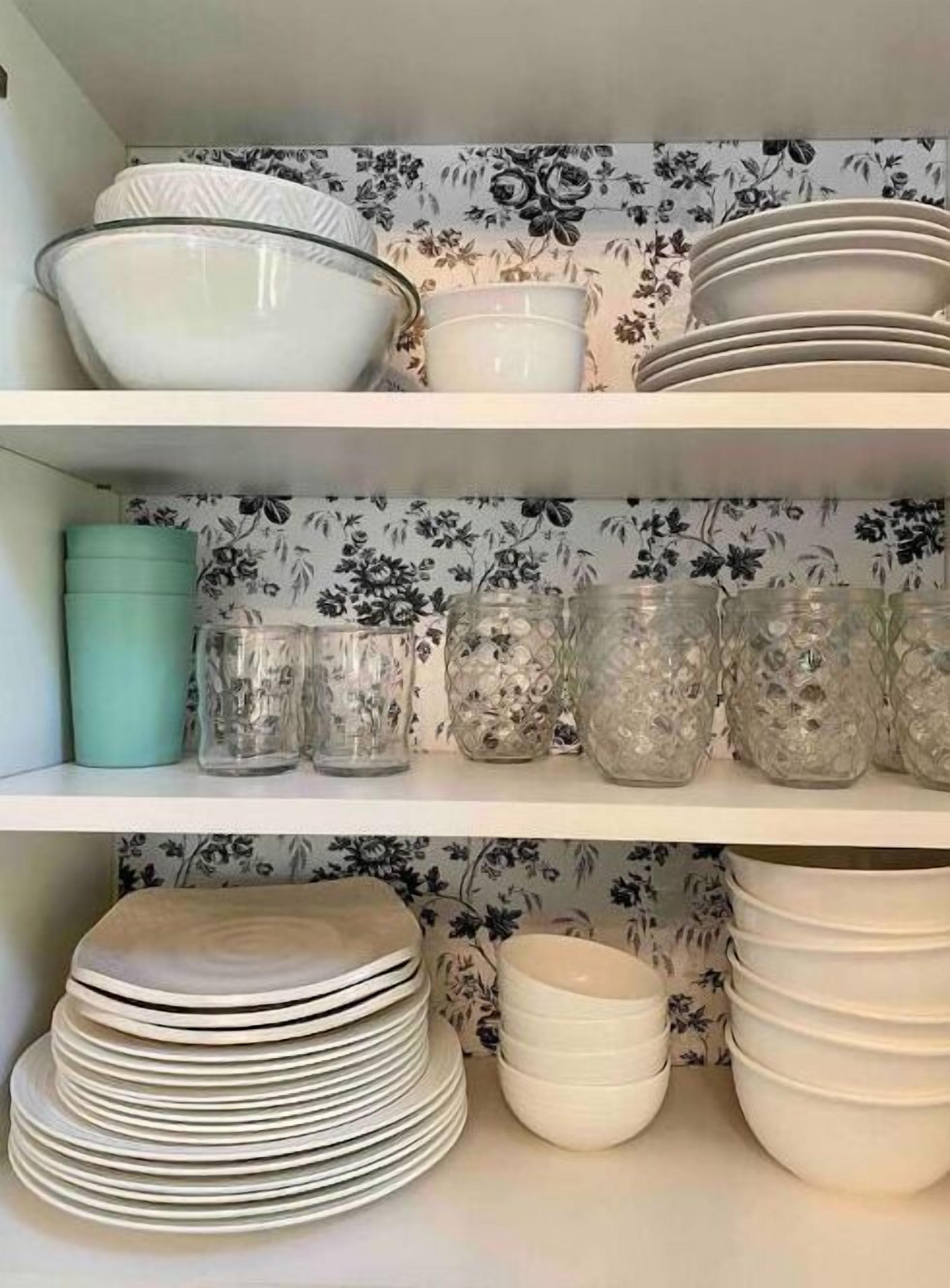 A kitchen shelf with various dishes and glassware.