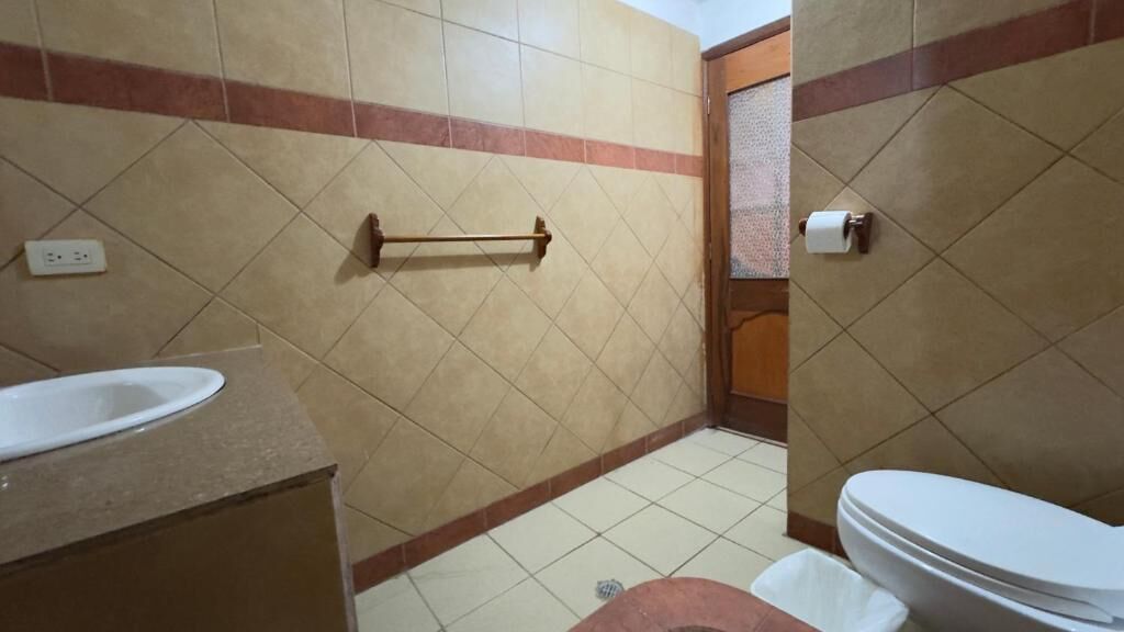 A bathroom with a sink, toilet, and a towel rack.