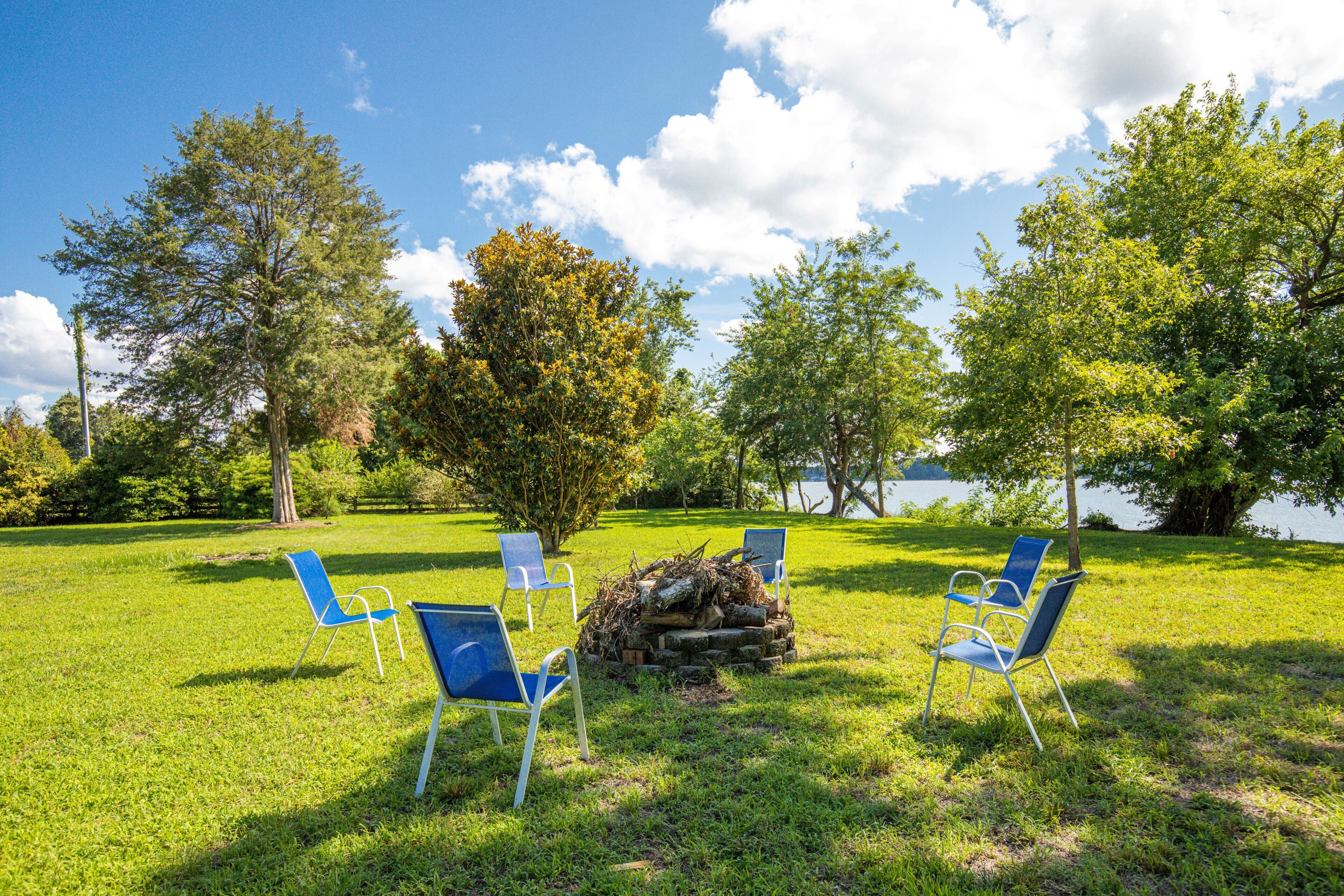Een gazon met vier blauwe stoelen rond een vuurkuil.