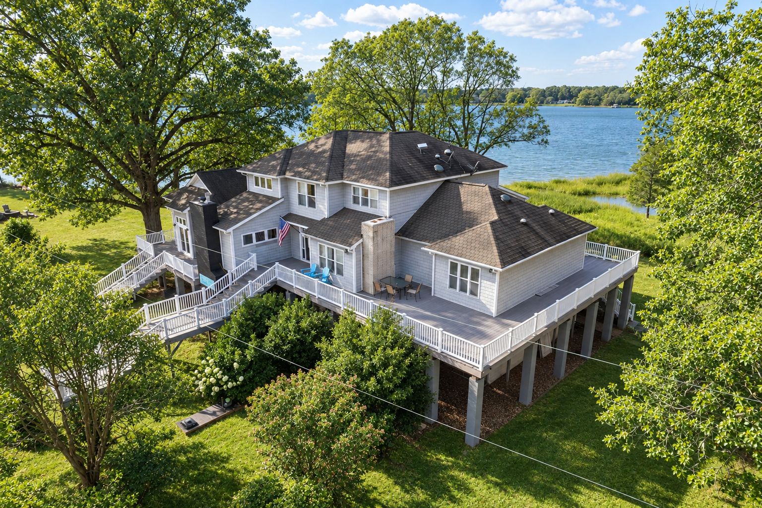 Une grande maison dotée de plusieurs terrasses et offrant une vue sur un lac.