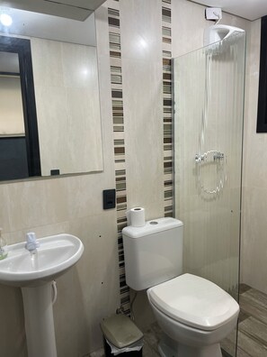 Een douche, handdoeken, zeep, toiletpapier