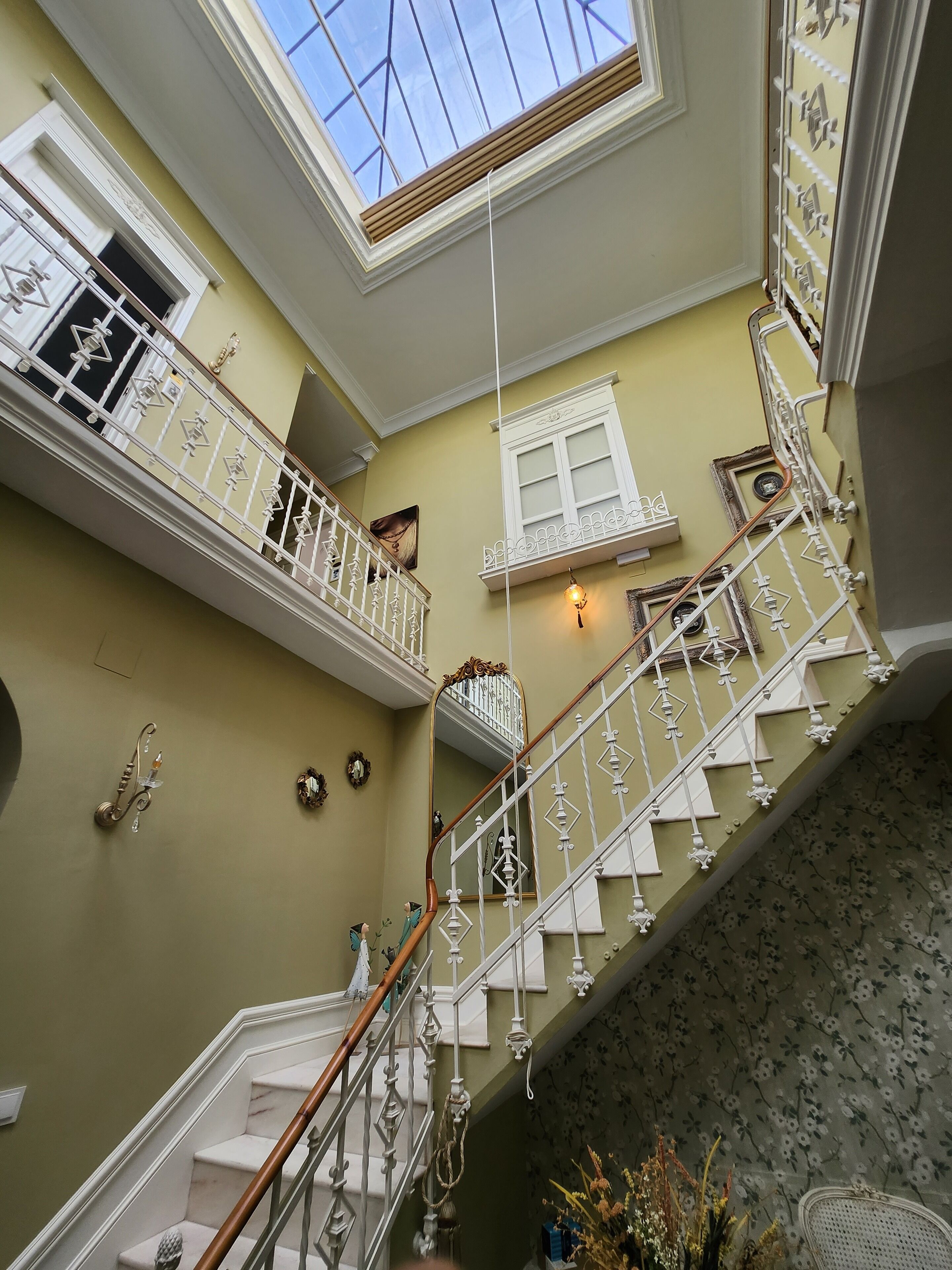 Un intérieur à plusieurs niveaux, doté d’un escalier, d’une lucarne et d’éléments décoratifs sur les murs.