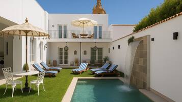 Una piscina al aire libre, tumbonas