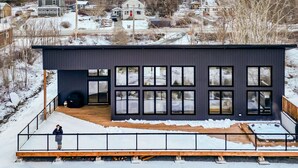A modern house with a large deck and multiple windows. - Dreamy Oceanfront Escape Hot tub & Sauna (South Shore)
