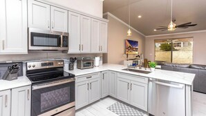 Una cocina moderna con electrodomésticos de acero inoxidable, armarios blancos y una isla grande.