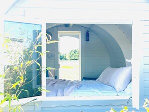 A bedroom with a bed, a window, and a view of the outdoors.