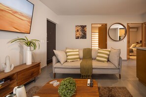 Relax in this stylish living room with a comfortable sofa, flat-screen TV, and potted plant.