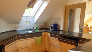 Eine Küche mit Dachfenster, einer Kaffeemaschine und einem Geschirrspüler.