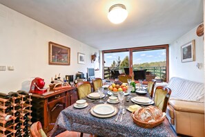 A dining area with a table set for four, a wine rack, and a view of the outdoors. - Hunting Lodge Hills Retreat, Ribnjačka, Croatia (Ribnjačka)