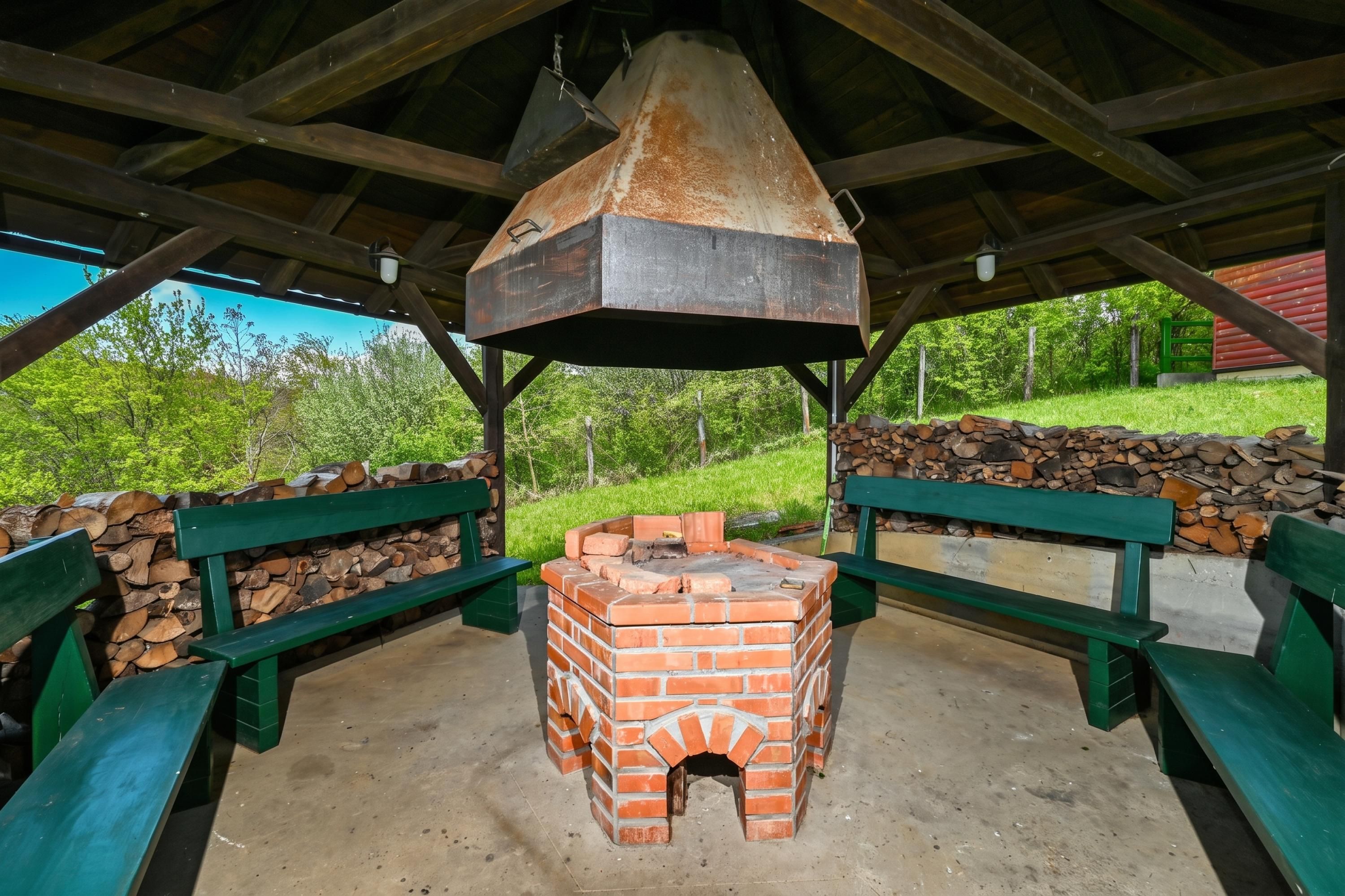 An outdoor brick oven under a wooden shelter with benches and a stone wall.