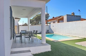 Enjoy a meal on the patio, surrounded by a well-maintained lawn and a small pool.