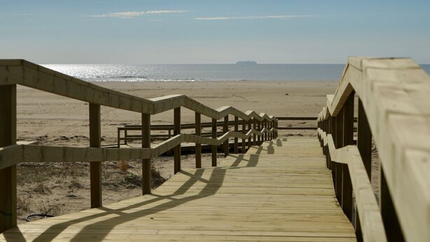 A wooden boardwalk leading to a beach with a clear view of the ocean. - Apartment Los Pelicanos (Ayamonte)