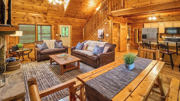 L’intérieur d’une cabane en bois comprend un salon, un coin repas, une cuisine et un escalier.