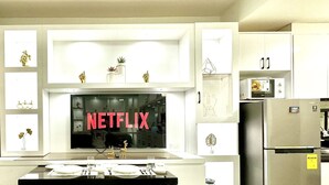 A modern kitchen with white cabinets, a built-in microwave, and a refrigerator. - Mall of Asia Shore 2 (Pasay)