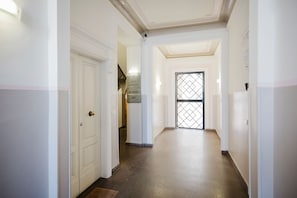 A hotel corridor with a closed door, a staircase, and a lift. - Cavour 96 Apartment in Firenze (Florence)