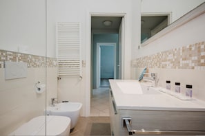 A bathroom with a bidet, a sink, and a mirror. - Cavour 96 Apartment in Firenze (Florence)