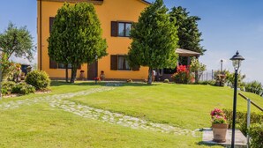 A yellow building with a paved pathway leading to a wooden door. - Leondina Country House with pool and panoramic view in Corinaldo, a heaven of peace in the Marche co (Corinaldo)