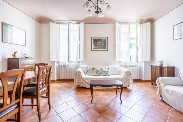 Una sala de estar amplia con un sofá, una mesa de comedor con sillas y un banco.