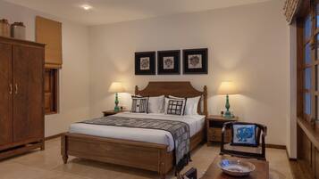 A bedroom with a wooden bed, bedside tables, a chair, and a cabinet.