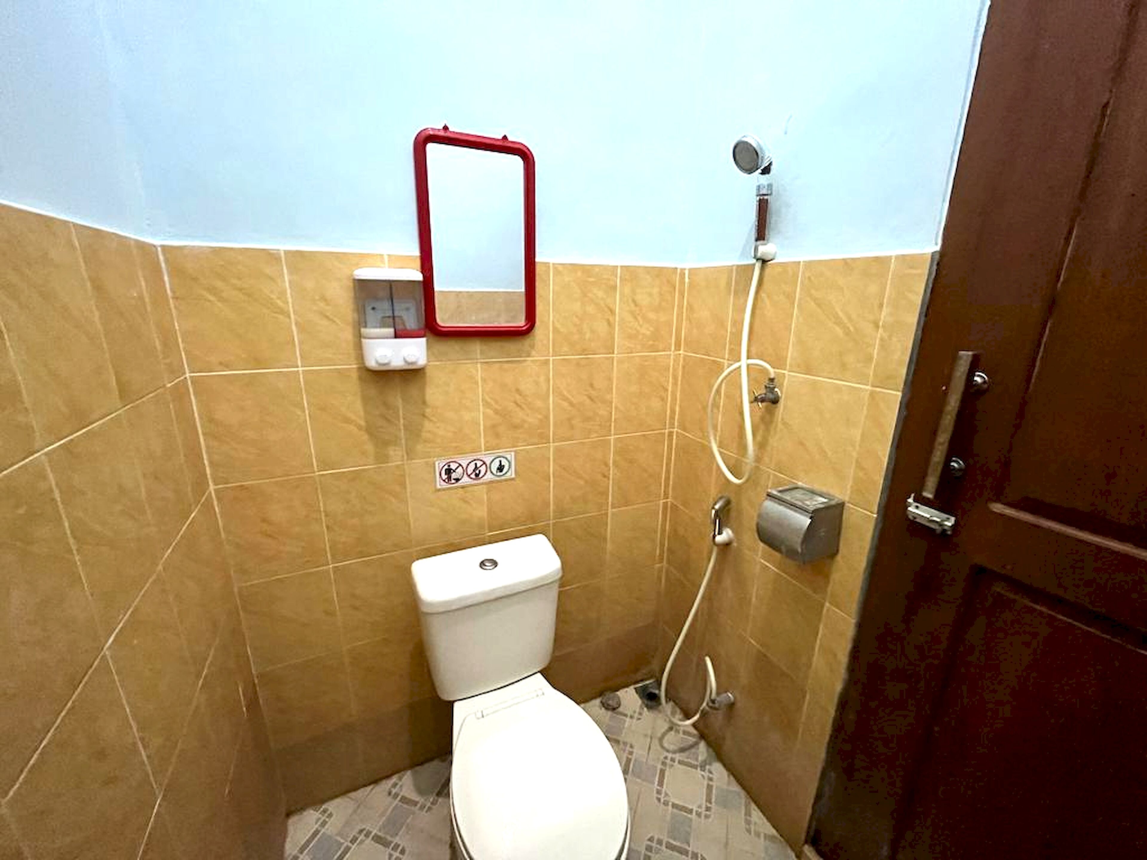 A small bathroom with a toilet, a shower, and a mirror.