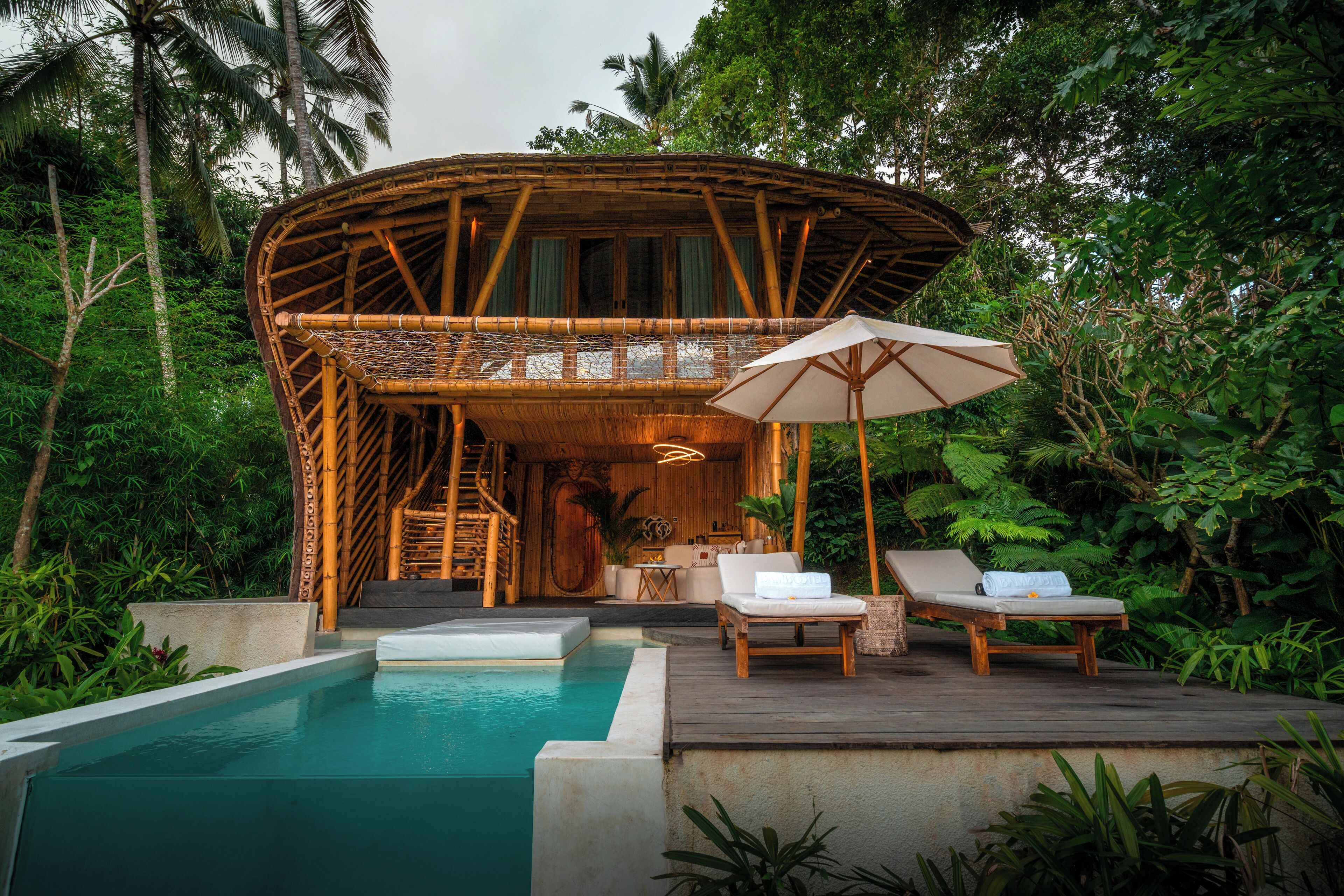 A wooden structure with a pool and lounge chairs.