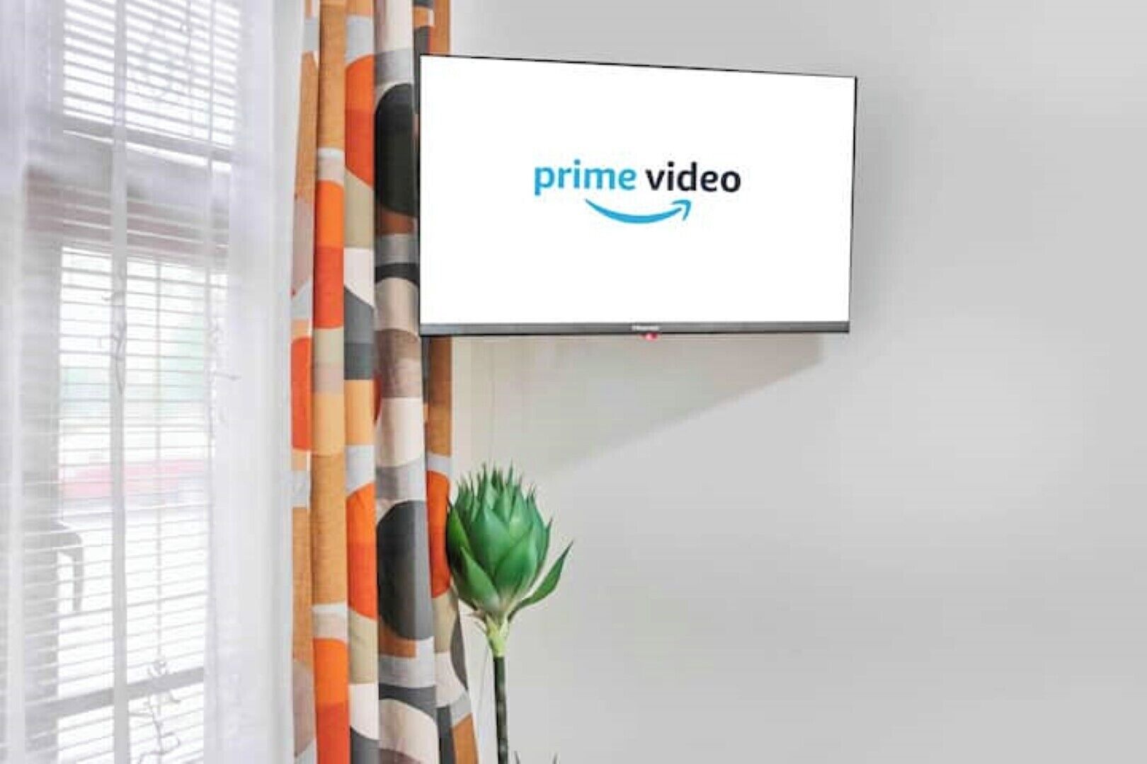 Un téléviseur à écran plat fixé au mur, sur lequel est affiché le logo de Prime Video.