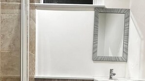 A modern bathroom with a toilet, sink, and shower area. - Spacious 3 Bed Flat in Greenwich for 6 (London)