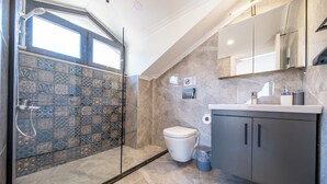 Un baño moderno con ducha, inodoro y lavamanos.