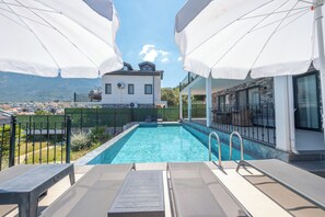 A swimming pool with a view of a mountain and a building in the background.