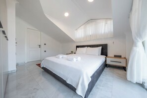 A modern bedroom with a large bed, a bedside table, and a nightstand.