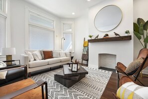 A modern living room with a sofa, coffee table, and fireplace. - Beatty`s Bohemian Retreat (Pittsburgh)