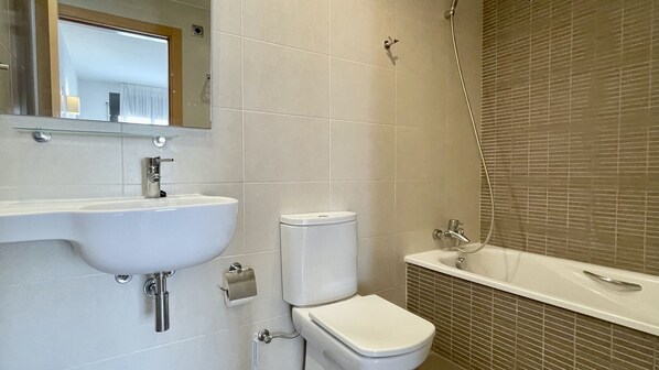 Une salle de bain avec un lavabo, des toilettes et une baignoire.