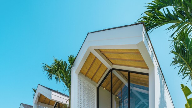 Una casa moderna con piscina, ventanas amplias y un porche cubierto.
