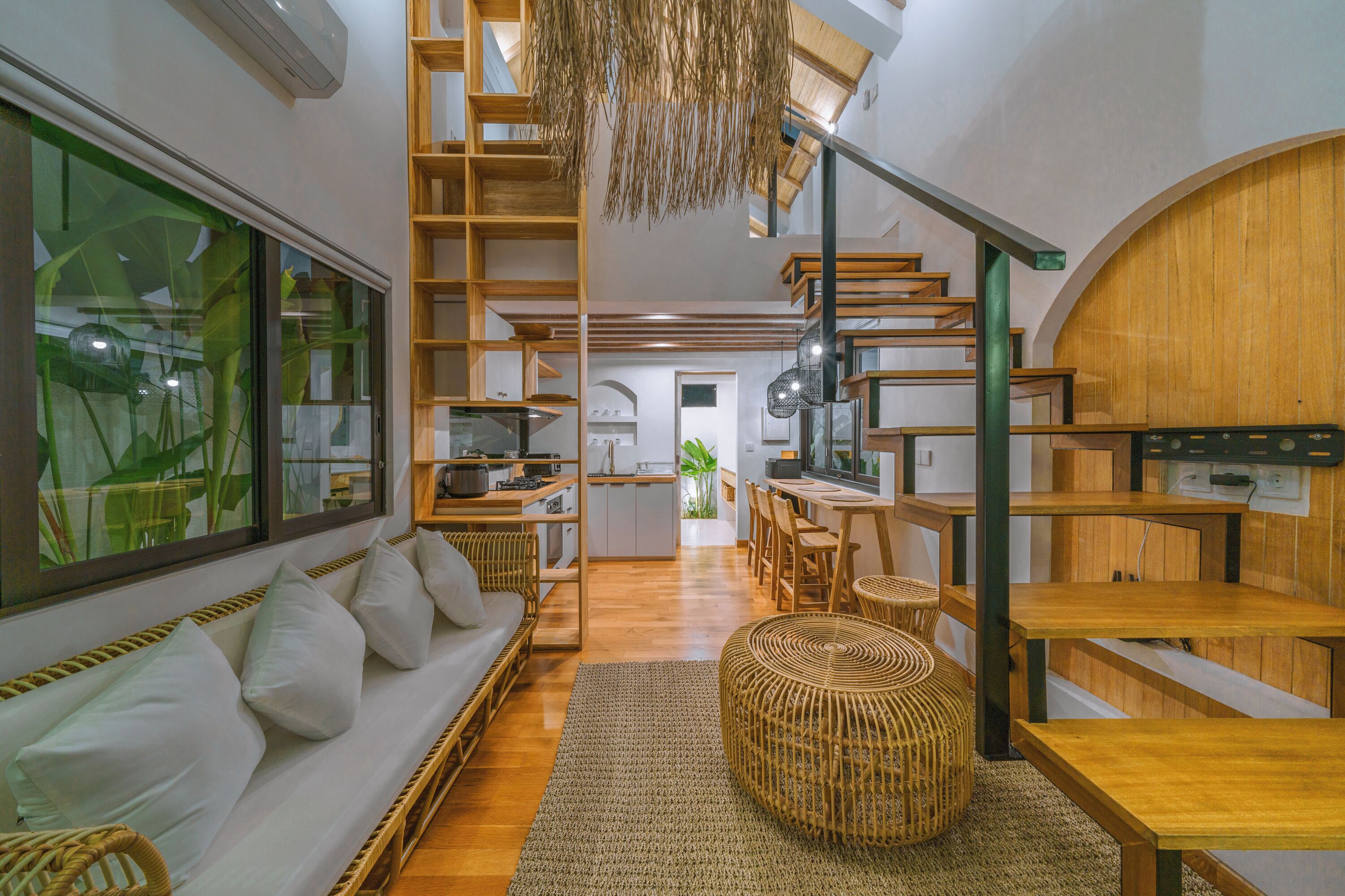 Un interior moderno con una escalera de madera, un comedor y una cocina.