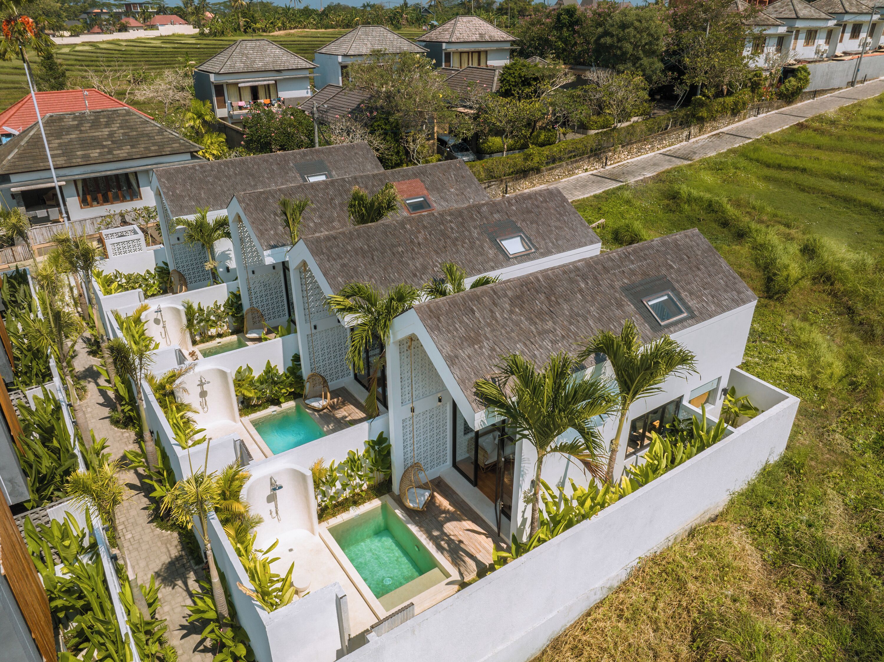 Una villa moderna con piscina, varias habitaciones y un jardín exuberante.