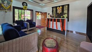 A spacious lobby with a seating area, a reception desk, and a ceiling fan.